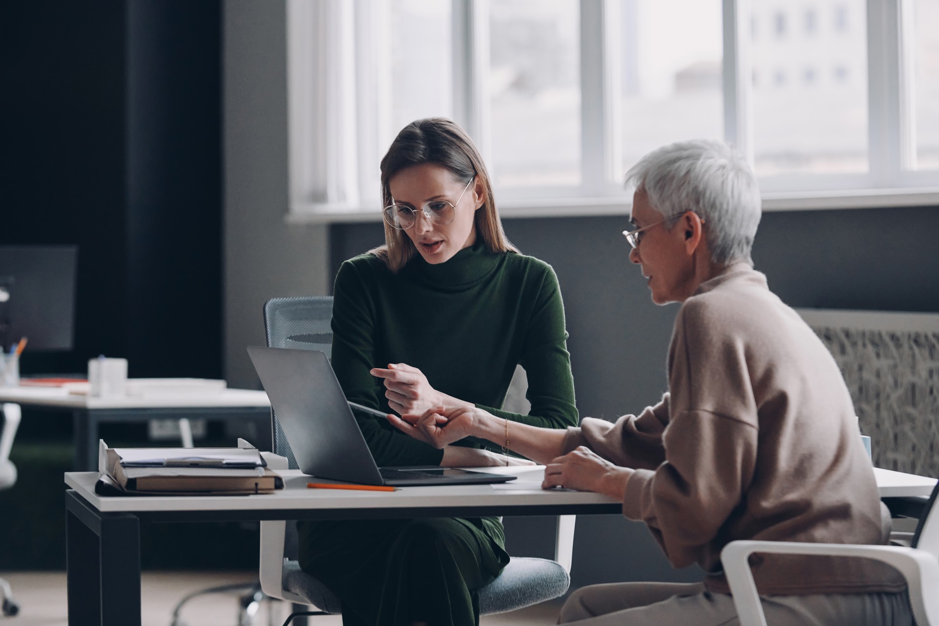 Confident financial advisor discussing options with senior woman in the office